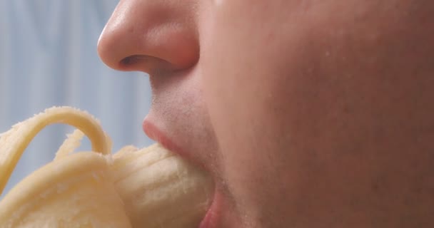 En man äter en banan närbild. — Stockvideo