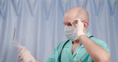 Doktor jinekolojik cihazı inceliyor..
