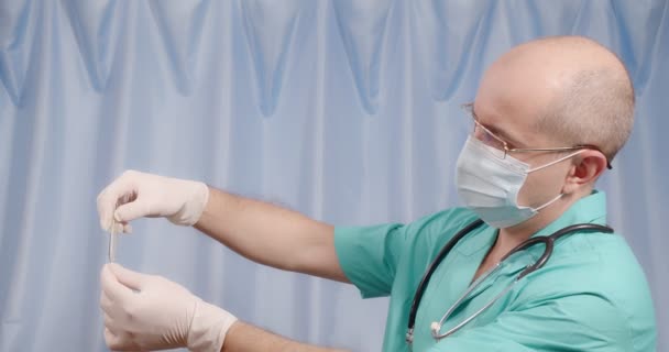 El médico observa la temperatura en un termómetro de mercurio. — Vídeos de Stock