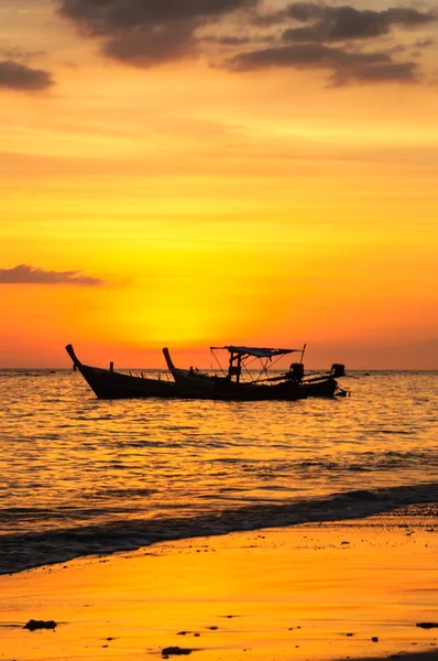 Silueta barco en la playa y puesta de sol — Foto de Stock
