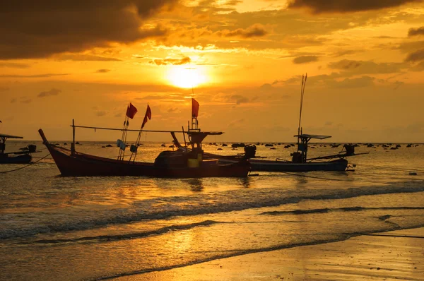 Silueta barco en la playa y puesta de sol — Foto de Stock