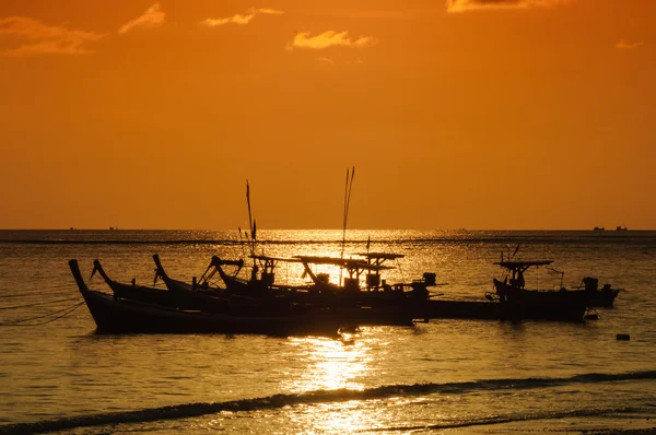 Silueta barco en la playa y puesta de sol —  Fotos de Stock