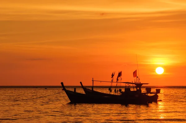 Silueta barco en la playa y puesta de sol —  Fotos de Stock