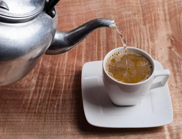 Taza de café y agua caliente en una mesa de madera — Foto de Stock