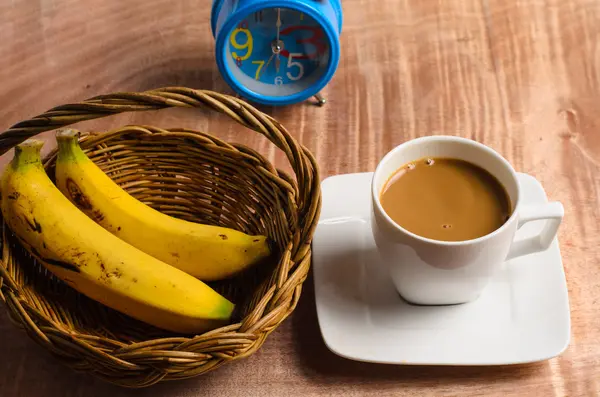 Taza de café y reloj en una mesa de madera — Foto de Stock