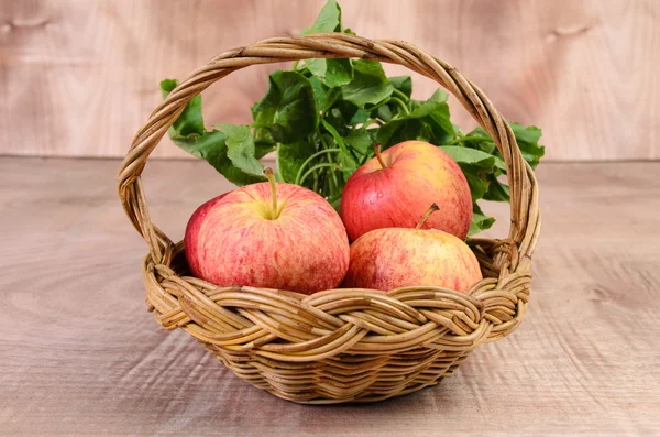 Apple and Asiatic in basket on wood background — Stock Photo, Image