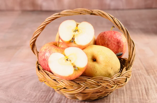 Manzanas en canasta sobre fondo de madera — Foto de Stock