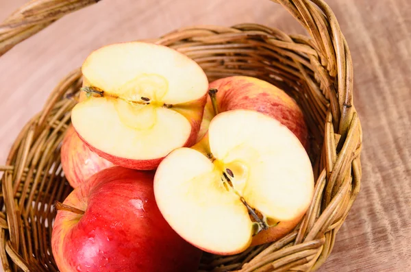 Manzanas en canasta sobre fondo de madera — Foto de Stock