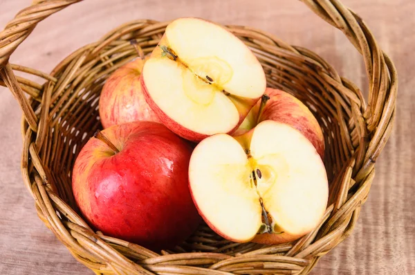 Manzanas en canasta sobre fondo de madera — Foto de Stock