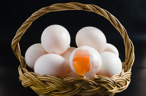 Verse eieren in een mand op zwarte achtergrond Rechtenvrije Stockafbeeldingen