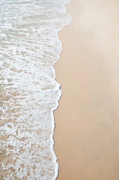Піщаний пляж і хвилясте море — стокове фото