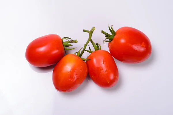 Manojo de tomates frescos con gotas de agua. Aislado en la espalda blanca — Foto de Stock
