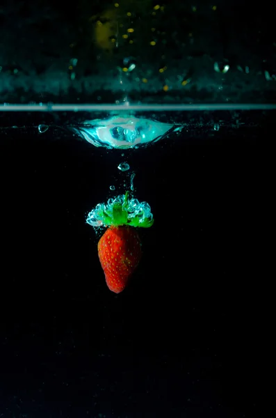 Spruzzi d'acqua alla fragola su sfondo nero — Foto Stock