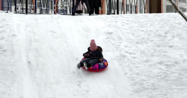 Παιδικές Διαφάνειες Στο Χιόνι Κορίτσι Γλιστράει Από Λόφο Χιόνι Σωλήνες — Αρχείο Βίντεο