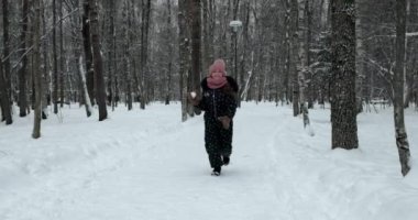 Küçük kız kameraya kartopu atıyor.