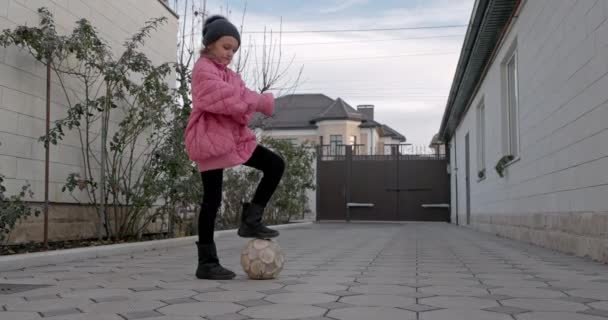 サッカーボールを持つ子供 10代の女の子が中庭で剣でサッカーを打つ — ストック動画