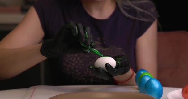 Девушка Рисует Пасхальные Яйца Руками Черных Перчатках — стоковое видео