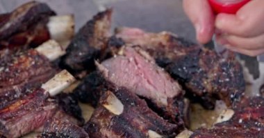 Bıçaklı erkek elleri Izgara kaburgalarını parçalara ayırır.