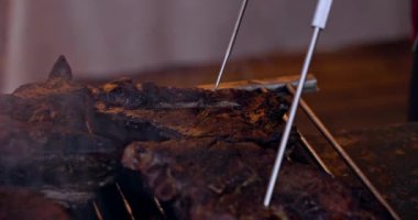 Grilled pork ribs on a flaming grill  with temperature sensors. Ribs on flaming grill barbecued.