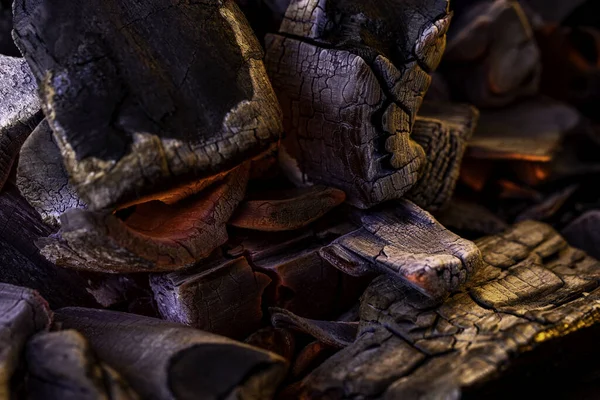Glowing Hot Charcoal Background Texture. Red hot coals in the grill close up. hot red coals among black ash, wallpapers for mobile devices, abstract.