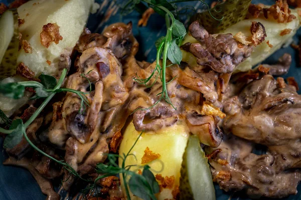 Beef stroganoff, goulash, with sauce and mushrooms, boiled potatoes.National Russian dish of beef stroganoff with meat, boiled potatoes, mushrooms and fried onions.