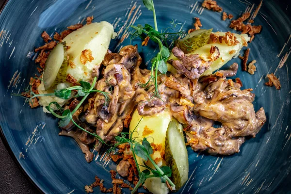 Beef stroganoff, goulash, with sauce and mushrooms, boiled potatoes.National Russian dish of beef stroganoff with meat, boiled potatoes, mushrooms and fried onions.