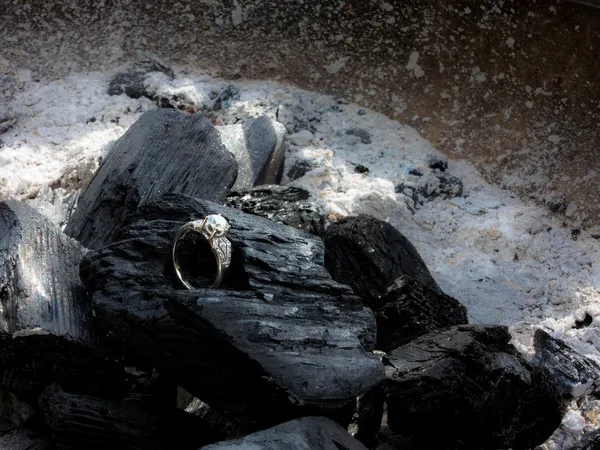 Diamantring onder kolen — Stockfoto