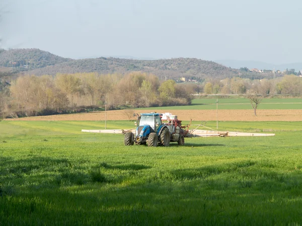 Tractor working spreading fertiliser — Stock Photo, Image