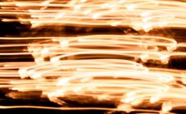 Yellow led lights out of focus and in photo with high exposure on black background making the painting effect making light lines in motion.