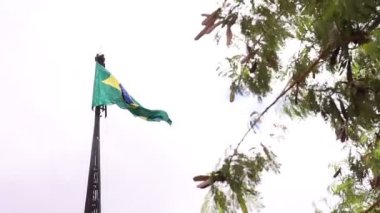 Brazil, Federal District - December 05, 2021: Mast and pavilion of the square of the three powers. The national Brazilian flag waving in the wind on a cloudy day. 