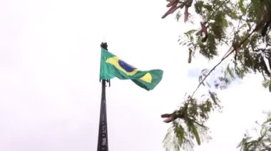 Brazil, Federal District - December 05, 2021: Mast and pavilion of the square of the three powers. The national Brazilian flag waving in the wind on a cloudy day. 