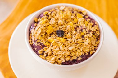 Frozen acai berry with granolas on wooden table background