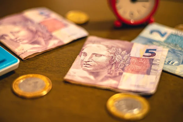 Real - BRL, money from Brazil. Folded money notes of the Brazilian Real in macro photography on a office table and coins