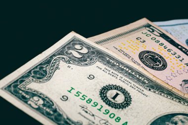 US dollar banknotes on a dark wooden table, close-up view