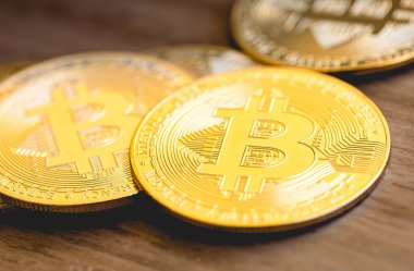 Golden bitcoins coins with Brazilian coins on a wooden surface. Cryptocurrency, finance and risk concepts.