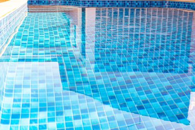 Vinyl lined pool. Outdoor photo of a mosaic-patterned residential swimming pool. Swimming pool with steps.