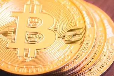 A stack of golden Bitcoin coins in macro photography. View from above. Virtual currency and payment method concepts.