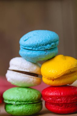 Macarons, sweet food. Biscuit made with almond flour. A stack of Macarons on a wooden board and a red napkin in the background. Food, Dessert, French, Sugar.