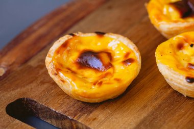Pastel de Belm or Pastel de Nata. Pastis de Belm on a wooden board ready to eat. Traditional sweet from Portugal.