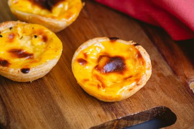 Pastel de Belm or Pastel de Nata. Pastis de Belm on a wooden board ready to eat. Traditional sweet from Portugal.