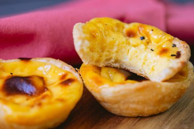 Pastel de Belm or Pastel de Nata. Pastis de Belm on a wooden board ready to eat. Traditional sweet from Portugal.