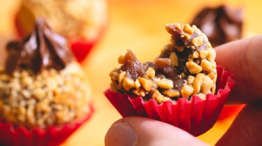 Man hand holding truffle decorated with hazelnuts 