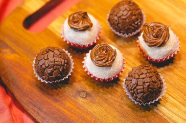 Süt tozu ve fındık kremalı Brezilya gurme tugayı ve tahta bir tahtanın üzerindeki tugayın geleneksel versiyonu. Yakın plan fotoğraf. Brezilya yemeği, tatlı. Partilerde ve etkinliklerde Brezilya 'dan geleneksel tatlı.