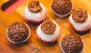 Süt tozu ve fındık kremalı Brezilya gurme tugayı ve tahta bir tahtanın üzerindeki tugayın geleneksel versiyonu. Yakın plan fotoğraf. Brezilya yemeği, tatlı. Partilerde ve etkinliklerde Brezilya 'dan geleneksel tatlı.