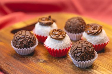 Süt tozu ve fındık kremalı Brezilya gurme tugayı ve tahta bir tahtanın üzerindeki tugayın geleneksel versiyonu. Yakın plan fotoğraf. Brezilya yemeği, tatlı. Partilerde ve etkinliklerde Brezilya 'dan geleneksel tatlı.