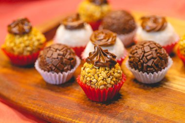 Brezilyalı gurme Brigadeiro. Tahta bir tahtanın üzerinde çeşitli aromalı tugaylar. Brezilya yemeği, tatlı. Brezilya 'da geleneksel tatlı partilerde ve etkinliklerde.