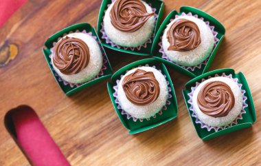 Tahtaya süt tozu ve fındık kremalı Brezilya gurmesi Brigadeiro. Yakın plan fotoğraf. Brezilya yemeği, tatlı. Brezilya 'da geleneksel tatlı partilerde ve etkinliklerde.