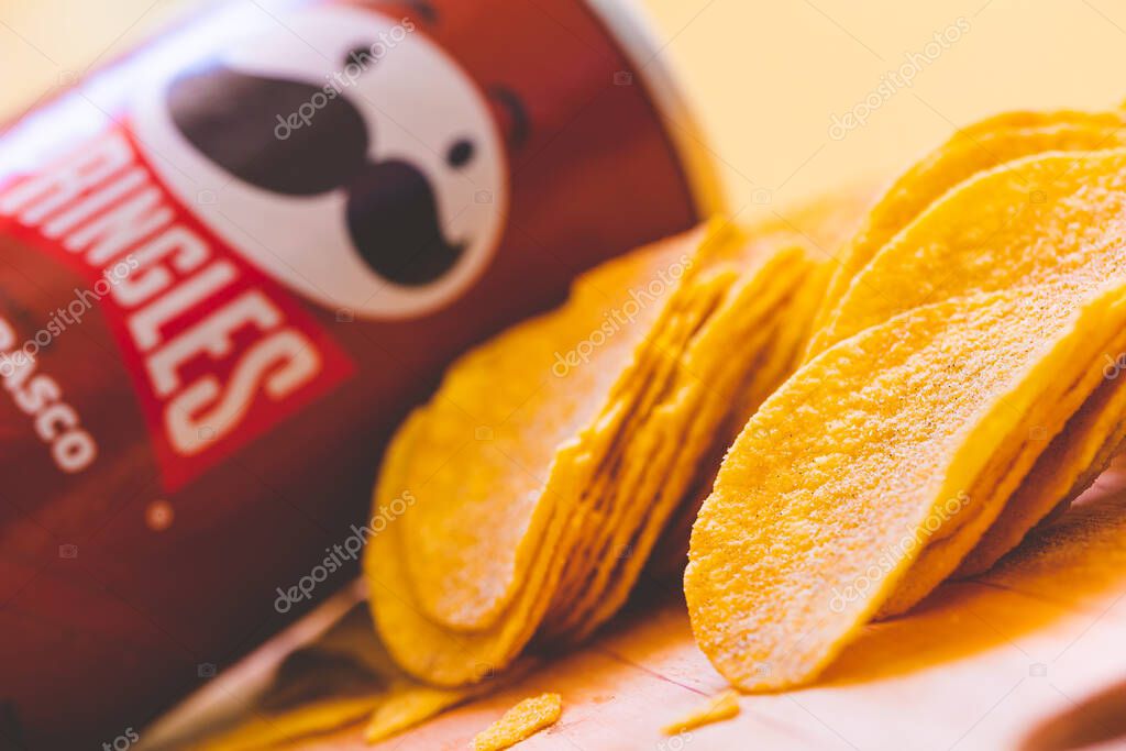 Brasilia, Federal District - Brazil. August, 30, 2022. barbecue-flavored pringles potato chips spread on a wooden board.