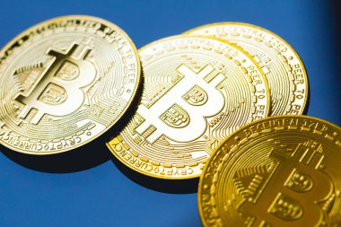 Bitcoin, BTC, kripto para birimi. Karanlık bir masanın yüzeyinde altın sikkeler ve yakın çekim fotoğraflarında cam..