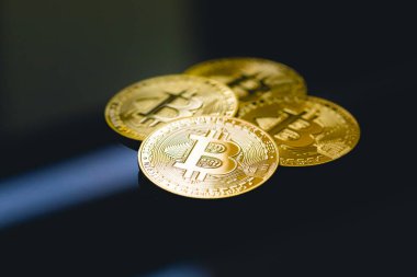 Bitcoin, BTC, kripto para birimi. Karanlık bir masanın yüzeyinde altın sikkeler ve yakın çekim fotoğraflarında cam..
